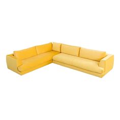 a yellow sectional couch sitting on top of a white floor