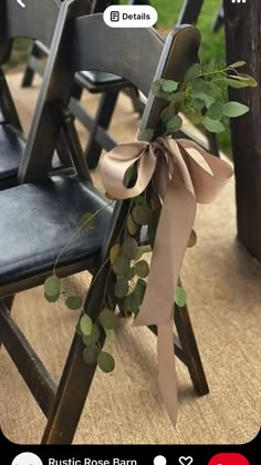 a row of wooden chairs with ribbons tied around the back of them and eucalyptus leaves on each chair