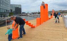 a man and child are standing on orange blocks