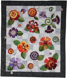 a quilted wall hanging with flowers on it