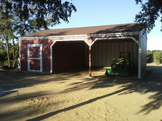 a garage with a tractor parked in front of it