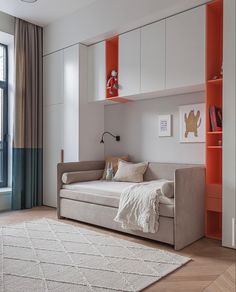 a living room filled with furniture and a large window next to a wall mounted book shelf