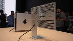 an apple computer is on display in front of a group of people looking at it