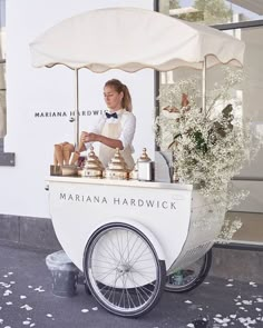 a woman is selling food from a cart