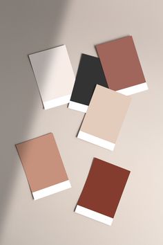 four different shades of brown, black, and tan on a white surface with shadows