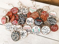 a bunch of christmas ornament hanging on a wooden board with string and twine