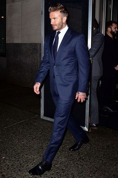 a man in a suit and tie walking down the street