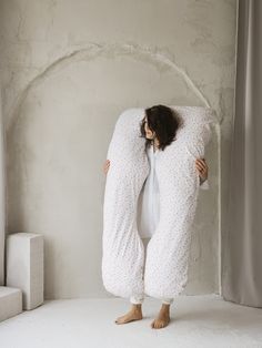 a woman is wrapped up in a large pillow