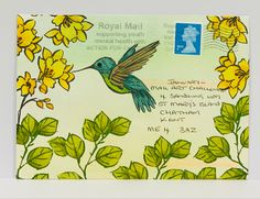 a postcard with a drawing of a hummingbird and yellow flowers in the background