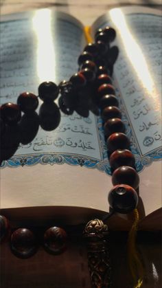 an open book sitting on top of a table next to beads and tassels