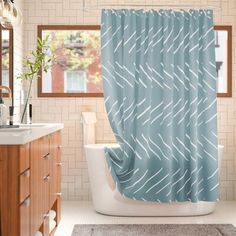 a bathroom with a tub, sink and shower curtain that has an arrow pattern on it