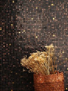 a basket filled with dried flowers sitting on top of a table next to a wall