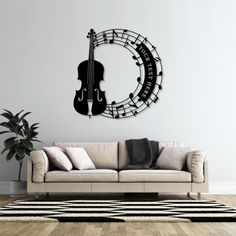 a living room with a couch and a violin wall clock