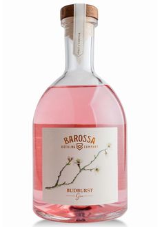 a bottle of pink liquid with a white label on the top and bottom, in front of a white background