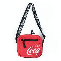 a small red bag with the word coca on it's side hanging from a black strap