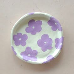 a paper plate with purple flowers painted on it