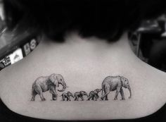 an elephant family tattoo on the back of a woman's upper arm and neck