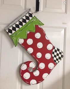 a red and white christmas stocking hanging on a door with black and white polka dots