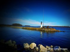 a light house sitting on top of a small island in the middle of a body of water