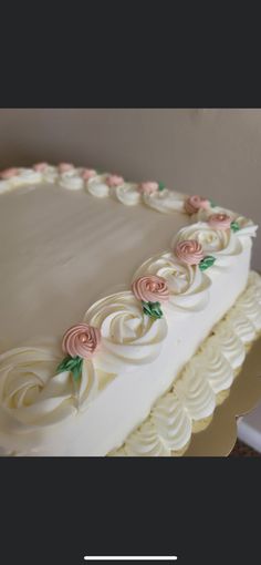 there is a large white cake with pink flowers on it