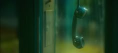 an old fashioned phone is hanging on the door handle in front of a window with blurry background