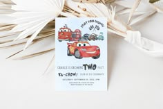 a birthday card with cars on it next to some palm fronds and leaves