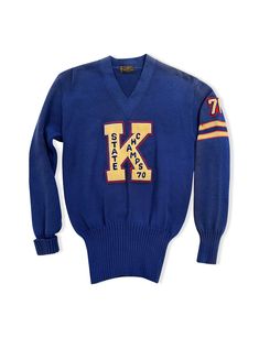 The label is "Art Knitting Mills" embroidery shop in Michigan. Brand is known for their 50's style letter sweaters. #71 on arm above stripes. This varsity letter sweater is navy blue with a large "K" letter patch. Material: Virgin WoolVintage product is for sale in USA only. Vintage High School, Vintage Varsity Sweater, Vintage Blue Sweater For College, Vintage Sweater With Ribbed Cuffs, Vintage Navy Sweater With Long Sleeves, Navy Vintage Long Sleeve Sweater, Vintage Sweater With Embroidered Logo For Fall, Blue Varsity Sweater With Ribbed Cuffs, Vintage Sweater With Embroidered Logo For College