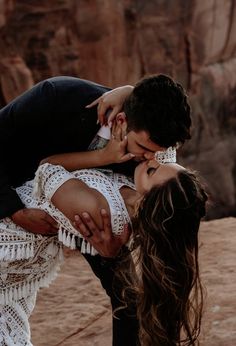 a man and woman kissing in the desert