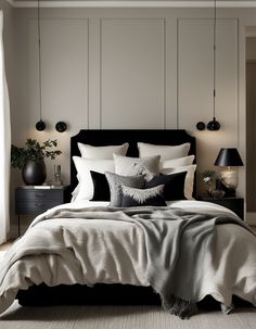 a bed with white sheets and black pillows