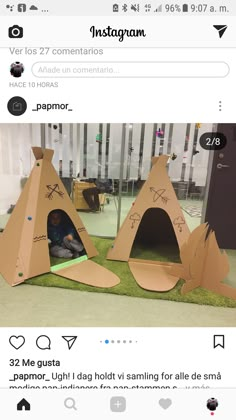 two cardboard tents sitting on top of green grass