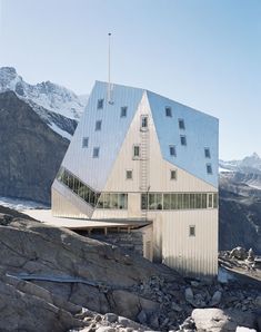 the building is on top of some rocks and has a roof made out of windows