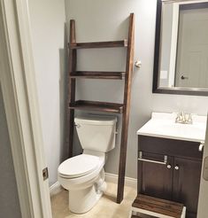 a bathroom with a wooden ladder leaning against the wall next to a toilet and sink