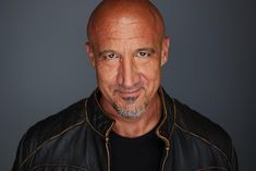 a man with a bald head wearing a leather jacket