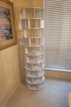 a tall white shelf sitting in the corner of a room