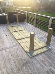 a wooden deck with metal posts and benches