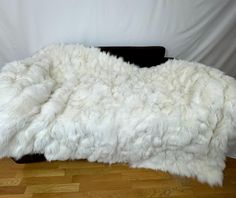 a white sheepskin blanket on top of a wooden floor