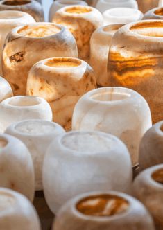 there are many different types of vases on the table, including one that is brown and white