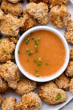 a white plate topped with tater tots and dipping sauce