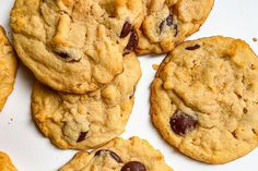 several cookies with raisins and chocolate chips arranged on a white surface, top view