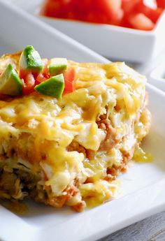 a white plate topped with lasagna covered in cheese and vegetables