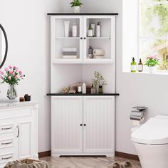 a bathroom with white cabinets and black counter tops, flowers in vases on the shelf