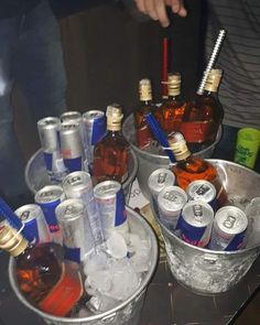 several buckets filled with different types of drinks on top of a table next to each other