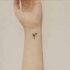 a small palm tree tattoo on the left wrist is shown in black ink, and it appears to be tiny