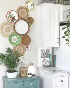 a kitchen with white cabinets and lots of plates hanging on the wall above the counter