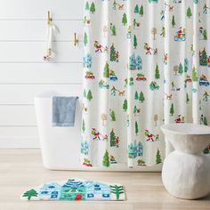 a bathroom with a shower curtain and rug on the floor next to it is decorated with christmas trees