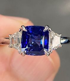 a blue and white diamond ring with three baguettes