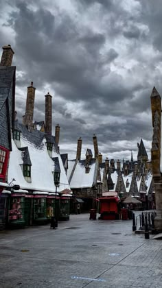 a row of buildings sitting next to each other on top of snow covered ground in front of cloudy sky