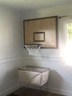 a basketball hoop mounted to the side of a wall in a room with wood flooring