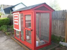 a small red chicken coop in the backyard