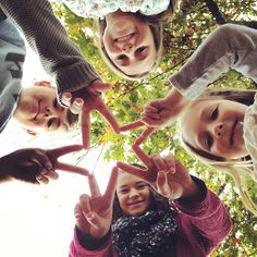 four children making a heart with their hands